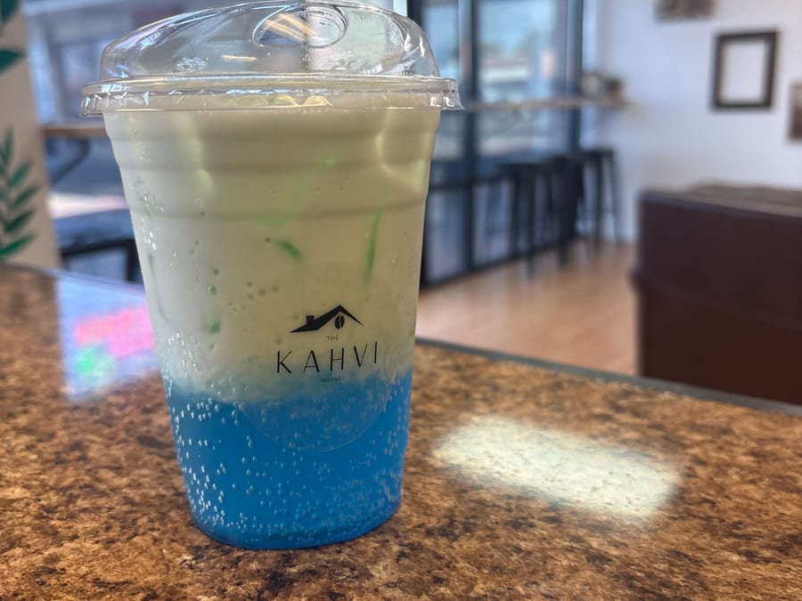 Cielo — blue raspberry and coconut tiki drink with a cream float, in a Kahvi House cup